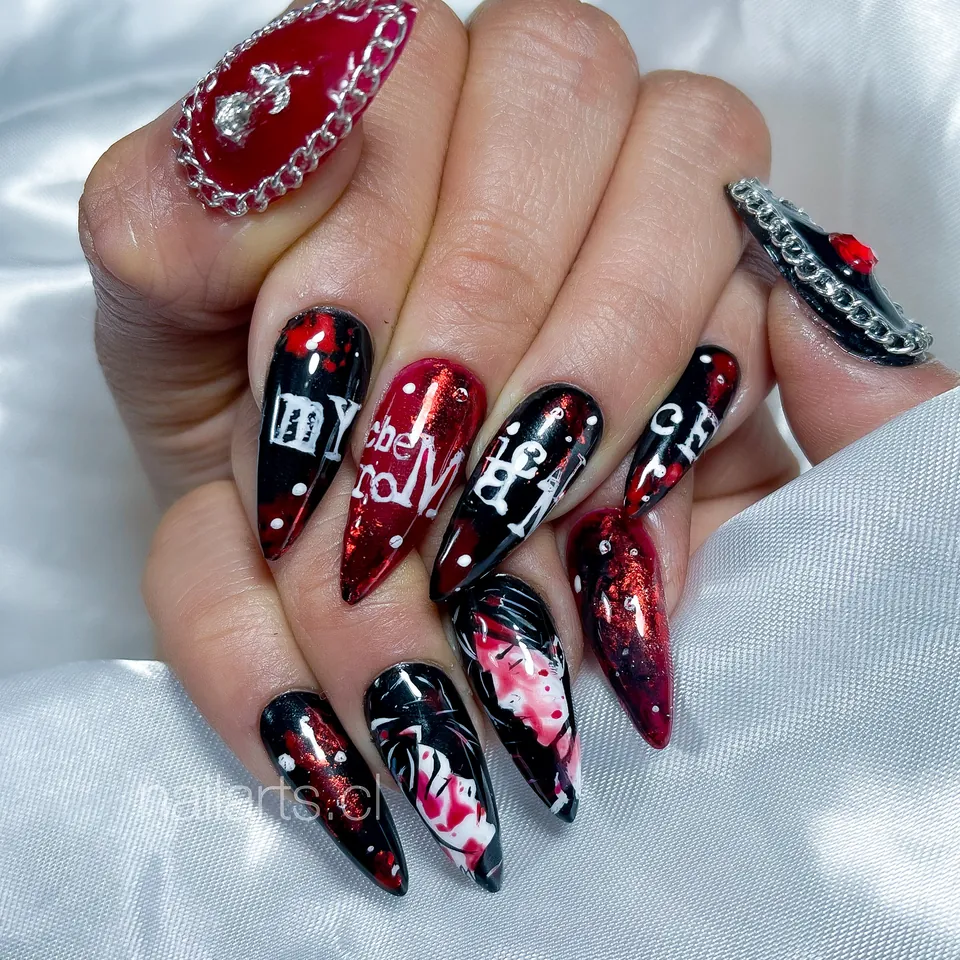 Uñas stiletto negras y rojas con cadenas, letras y personajes pintados
