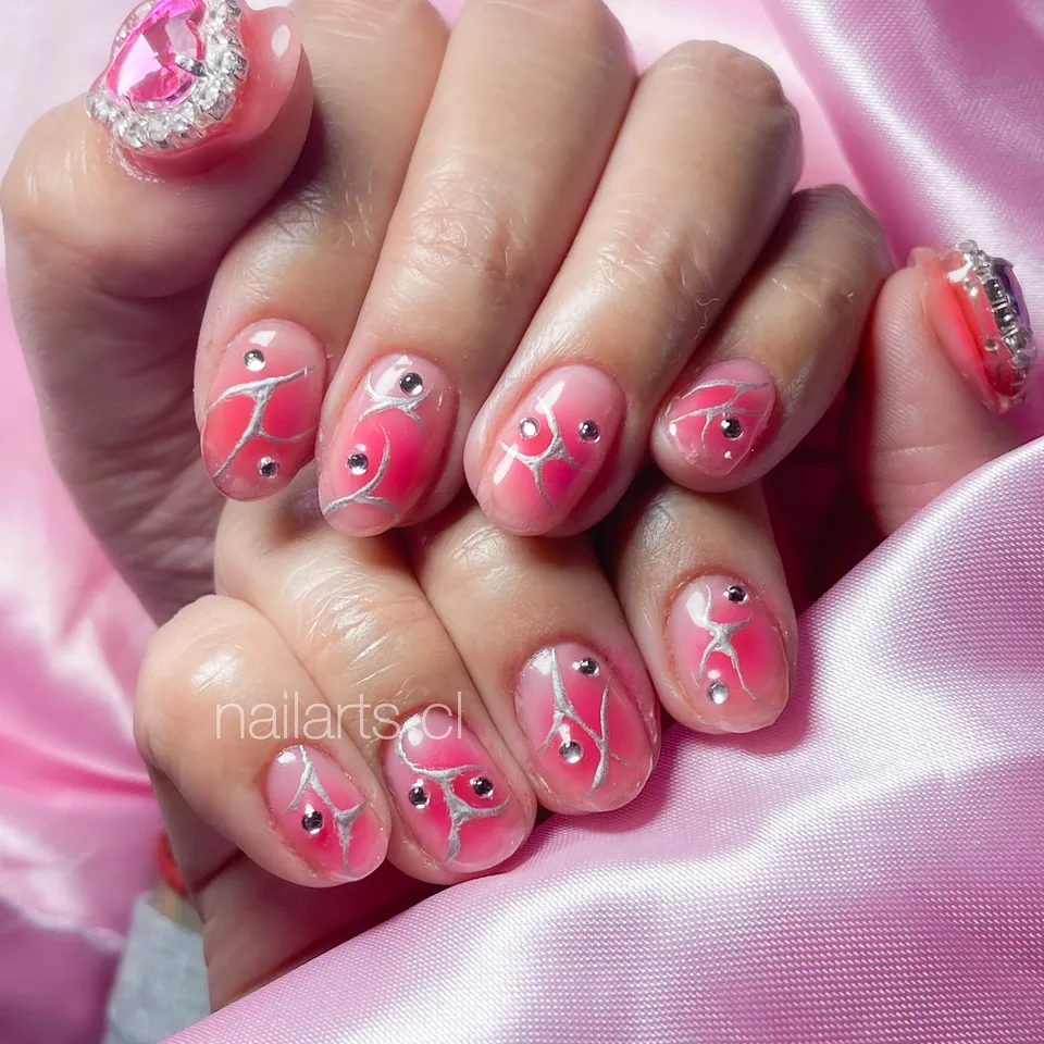 Uñas rosadas con líneas blancas y cristales